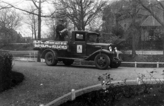 Een zwart-wit foto van een ouderweste pick-up die langs de huizen ging om gebruikte spullen en textiel op te halen voor het Leger des Heils